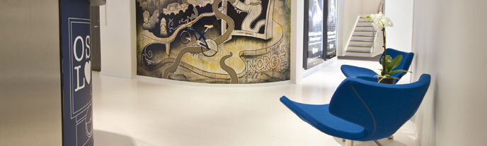 En vit korridor med två blåa fotöljer.